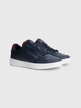 Zapatillas urbanas Tommy Hilfiger color azul marino, con cordones, suela blanca y detalles en rojo. Logo de la marca en el lateral y la lengüeta.