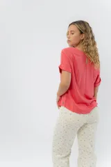 Remera blanca de viscosa liviana, con escote redondo y mangas cortas con vuelta.