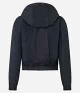 Campera rompevientos deportiva color blanco, confeccionada en poliamida, con capucha, cierre delantero en cremallera, tirador gomoso y puños ajustados.