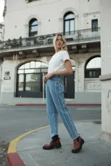 Pantalón jean celeste claro, corte mom, con flecos en los laterales.