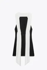 Minivestido negro con cuello halter y espalda descubierta. Presenta un panel blanco en la parte superior delantera y forro interior.