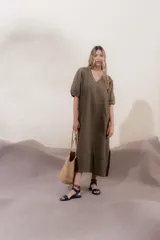 Vestido largo rojo con escote en V, mangas abullonadas con elástico en el puño y detalle de pespunte en contraste. Presenta un canesú con efecto punto smock y bolsillos laterales.