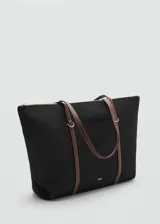 Bolso shopper negro con forro interior, tejido de nylon y tiras de color marrón en contraste. Tiene doble asa corta, asa de hombro, bolsillo exterior y cierre de cremallera.