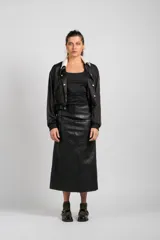 Falda larga de cuero negro, confeccionada con paneles rectangulares, de corte recto y cierre trasero.