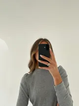 Remera manga larga color verde oliva, confeccionada en tejido morley de algodón con detalle fruncido en los hombros.