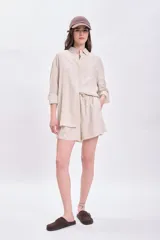 Short casual color beige confeccionado en lino, con cintura elastizada y cordón ajustable.