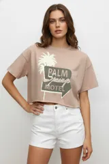 Remera blanca de algodón con estampado de texto y gráficos alusivos a la playa. Corte crop y cuello redondo.