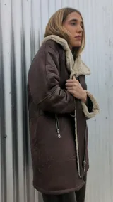 Chaqueta marrón gastado de cuero ovino con cuello y puños de piel sintética color crudo. Cierre frontal con cremallera y bolsillos laterales.