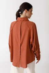 Camisa blanca de lino con botones de madera, corte recto y mangas largas.