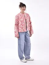 Chaqueta corta color salmón con estampado floral blanco, cuello mao y cierre frontal con botones de madera.