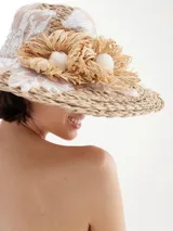Sombrero de rafia con apliques decorativos, ideal para días soleados.
