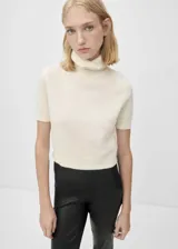 Jersey de cashmere color crema, con cuello alto y mangas cortas.