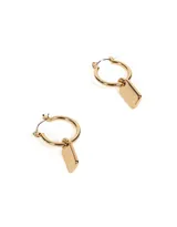 Aros tipo argolla bañados en oro con dije rectangular de metal pulido.