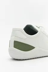 Zapatillas de cuero color blanco y beige, de diseño minimalista con suela marrón.