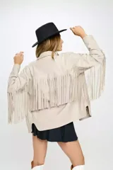 Chaqueta color beige con flecos en las mangas, cierre con botones y bolsillos en el pecho.