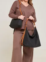 Bolso negro tipo tote con asas de cuero color marrón claro.