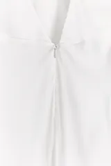 Top blanco de breteles finos, escote en V y abertura lateral.