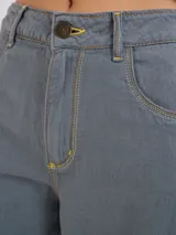 Pantalón gris de tiro medio alto, corte ancho, con bolsillos delanteros y traseros, detalles de atraques y triples costuras en color amarillo.