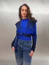 Buzo tejido en lana merino superwash teñido en degradé, con lazos que parten de la cintura alta para anudar de diversas maneras. Tiene mangas entalladas con ojal para el pulgar.