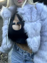 Chaqueta corta de piel sintética color gris con cuello alto y cierre metálico.
