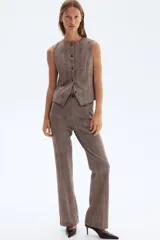 Chaleco entallado con estampado a cuadros, cuello redondo y cierre frontal con botones.