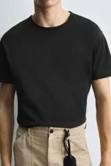 Camiseta verde militar de corte holgado confeccionada en tejido de algodón compacto. Cuello redondo con ribete doble y mangas cortas.