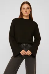 Sweater de viscosa color negro, con cuello polera, corte holgado, manga larga y detalle de pespunte vertical en el frente.