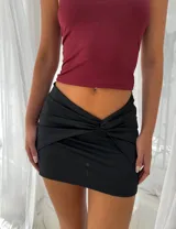 Minifalda negra con detalle de nudo en la parte delantera.