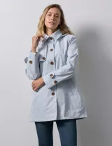 Gabardina color beige, impermeable, con abertura central con botones, bolsillos delanteros y capucha desmontable.