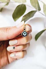 Dije artesanal de ojo turco con aro de plata 925.