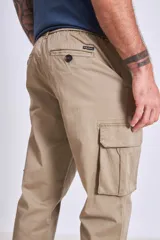 Pantalón cargo color beige, de corte recto, con bolsillos laterales con fuelle y cierre de solapa.