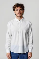 Camisa blanca de manga larga con cuello clásico y cierre frontal con botones.