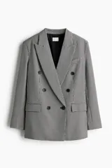 Blazer oversized de doble botonadura con solapas de pico y botones adelante. Modelo con hombreras, bolsillo superior insertado, bolsillos delanteros con solapa y botones decorativos en los puños. Abertura atrás. Forrado.