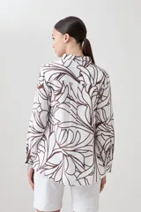 Camisa de lino color blanco con estampa abstracta color chocolate, de manga larga y cuello clásico.