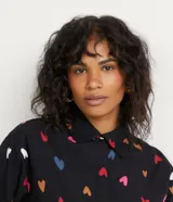 Camisa de manga larga negra con estampado de corazones multicolores.