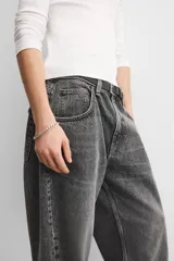 Pantalón de jean celeste con efecto lavado, corte amplio tipo baggy y cinco bolsillos.