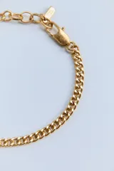 Set de tres pulseras doradas con diferentes diseños de eslabones.