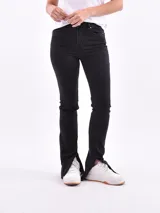 Pantalón de jean negro de corte recto con aberturas en el ruedo.