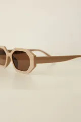 Lentes de sol con marco hexagonal de policarbonato en color bordó y cristales oscuros. Cuentan con protección UV400.