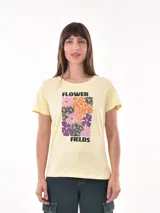 Remera color amarillo pastel con estampado de flores y texto "Flower Fields".