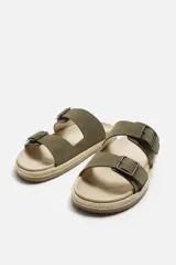 Sandalias marrones de piel con doble tira ancha en el empeine y cierre mediante hebilla. Plantilla con horma anatómica y suela forrada de yute.