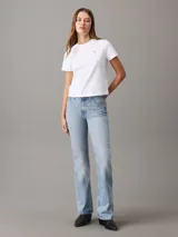 Remera blanca de algodón con cuello redondo, mangas cortas y corte relaxed. Presenta un pequeño logo de la marca bordado en el pecho y un estampado con el logo de Calvin Klein en la espalda.