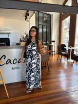 Vestido largo azul marino de tejido acanalado, con escote redondo y mangas cortas tipo hombrera. Presenta una abertura lateral en la falda.