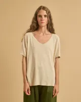 Remera color beige de corte holgado, con escote en V y mangas cortas.