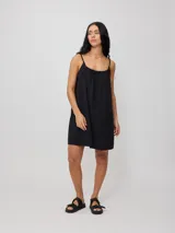 Vestido corto de algodón y lino color negro, con tirantes finos y escote recto con lazo ajustable.