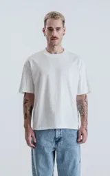 Remera blanca de algodón con corte crop, calce oversize, hombros caídos y cuello redondo.