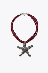 Collar de cordón doble color borgoña con dije metálico en forma de estrella de mar plateada con incrustaciones de strass.