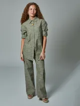 Camisa de manga larga color ladrillo con rayas blancas, confeccionada en lino. Tiene cuello clásico, cierre frontal con botones y bolsillo de parche en el pecho.