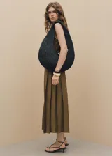 Vestido midi color marrón claro, sin mangas, con cuello camisero, cierre frontal con botones y cinturón con hebilla.