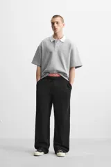 Pantalón jogger negro de corte ancho, confeccionado en tejido de algodón con interior de rizo. Cuenta con cintura elástica ajustable con cordón interior, bolsillos laterales y bolsillo trasero de parche.